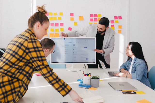 office meeting with man pointing to visual display