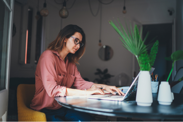 woman typing on a laptop at a table